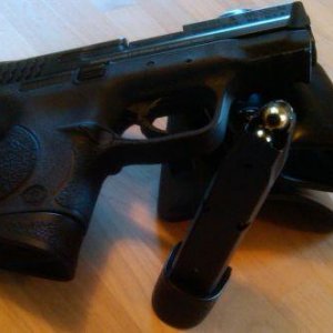 Smith M&P 9c laying right side up on galco matrix with spare mag